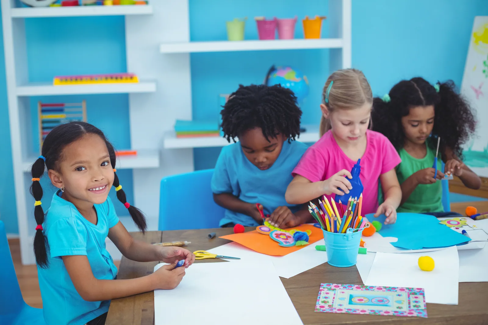 Kinder gestalten gemeinsam mit Farben und Papier.